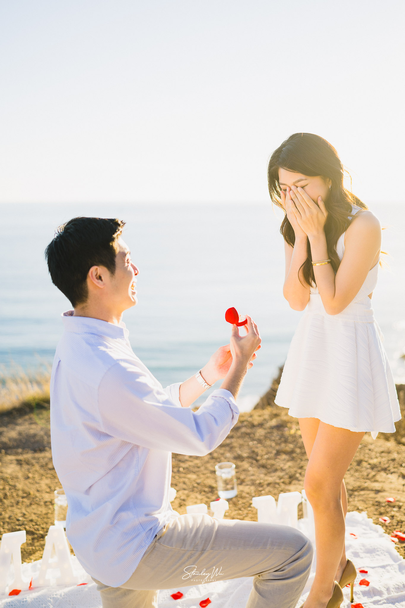 Man proposing to his fiance atop the cliffs in Malibu, fiance is crying tears of joy
